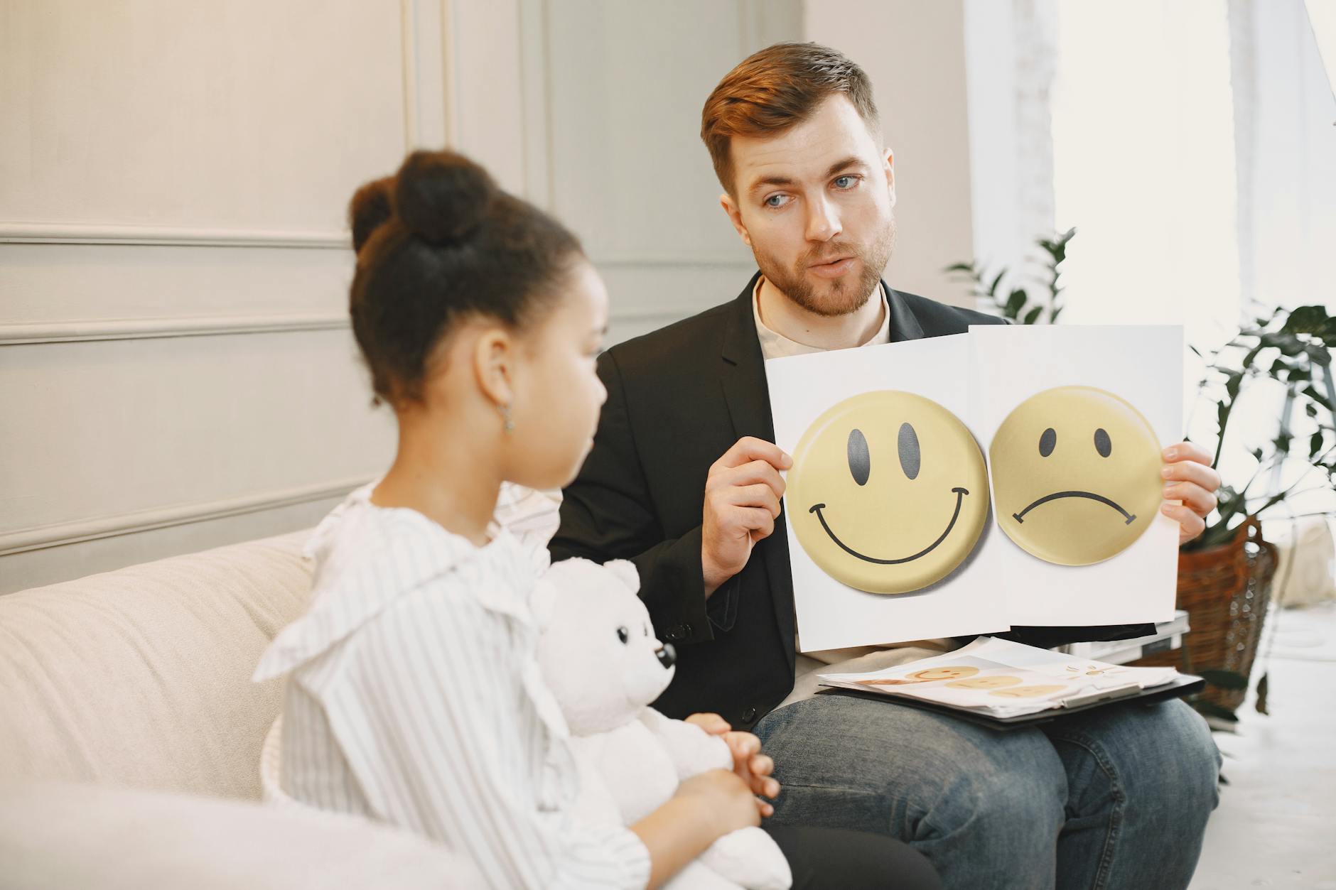 Terapeutka pomaga dziecku nazwać emocje za pomocą kolorowych kart