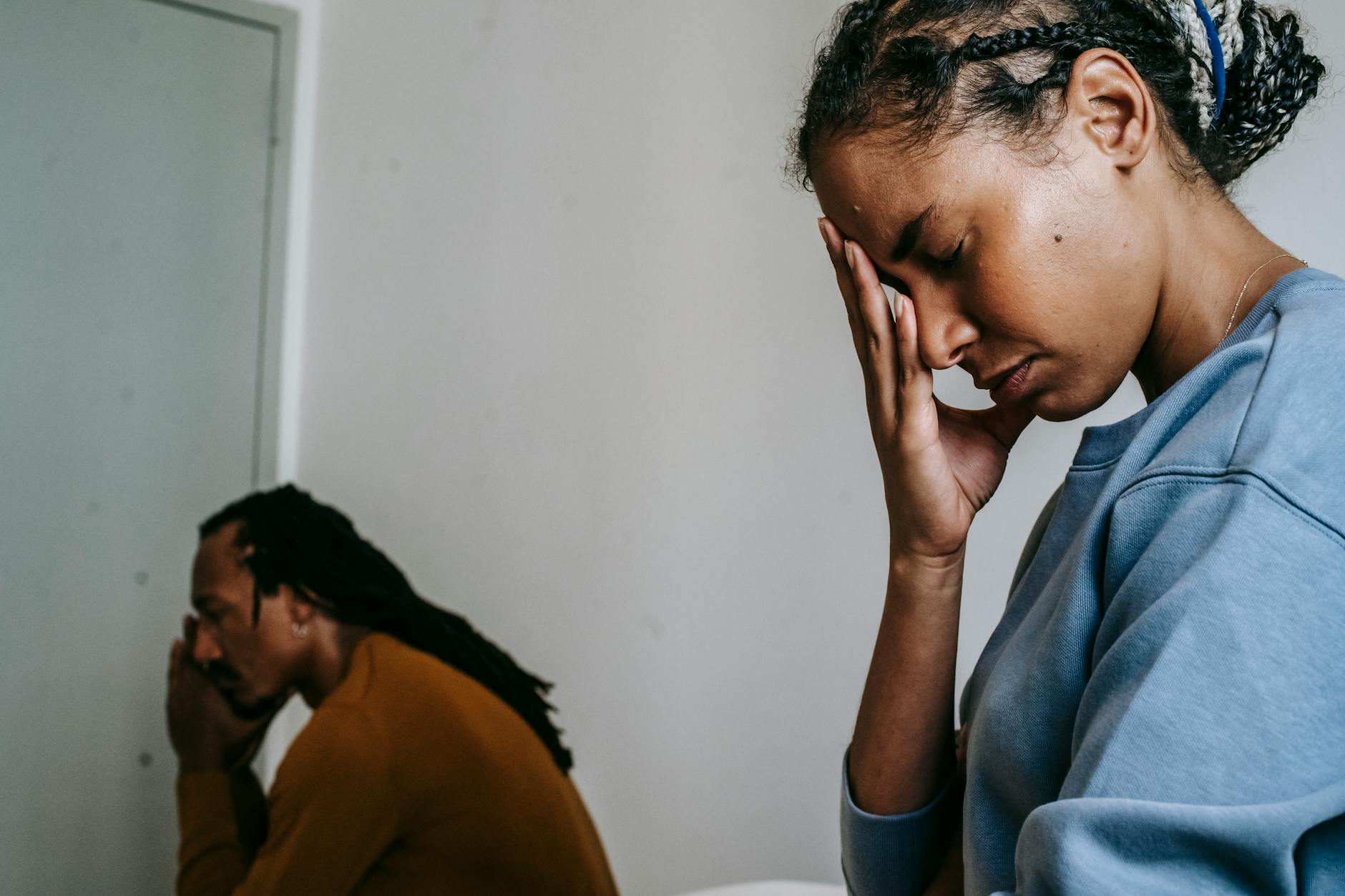 Zamartwiająca się młoda czarna para siedząca razem w ciągu dnia